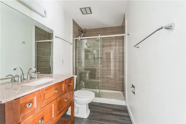 a bathroom with a granite countertop sink toilet and shower