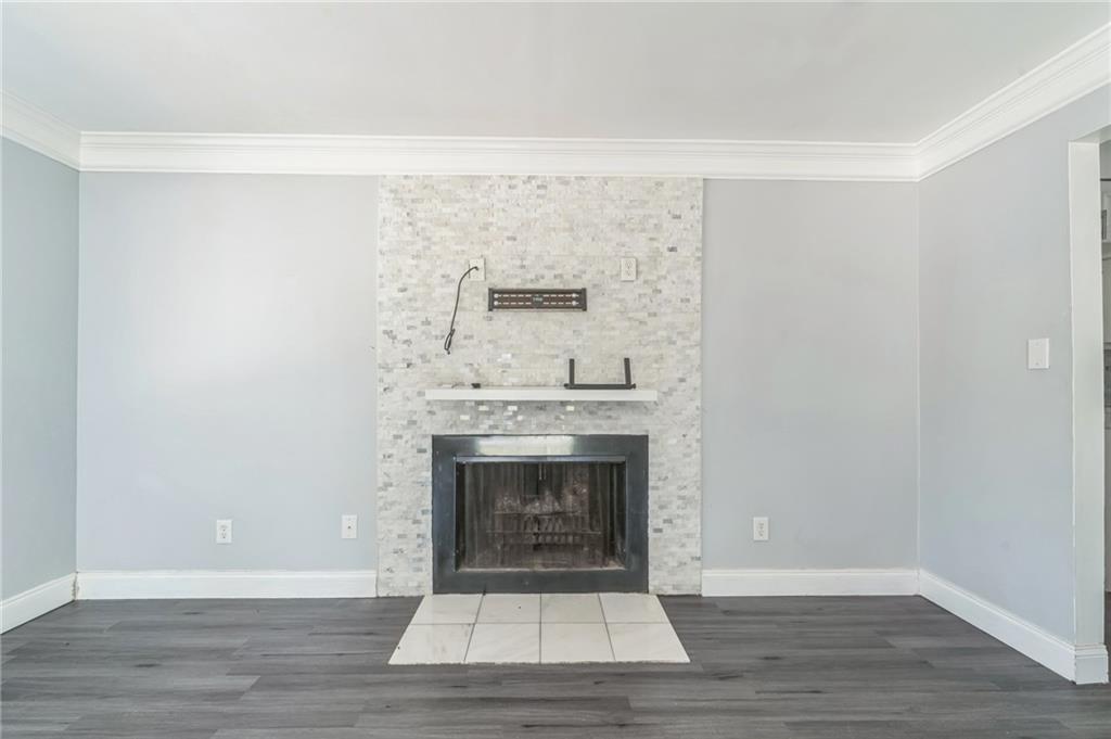 18 Quail Run, Unit A Decatur, GA 30035 - Photo 24 of 28 a view of an empty room with wooden floor and a fireplace