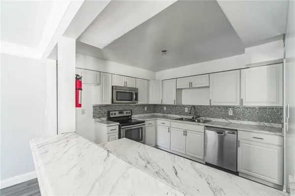 a kitchen with stainless steel appliances kitchen island granite countertop a sink stove and refrigerator