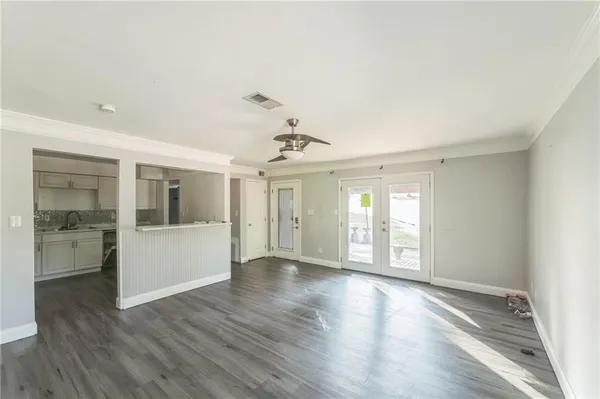 a view of an empty room with window and wooden floor
