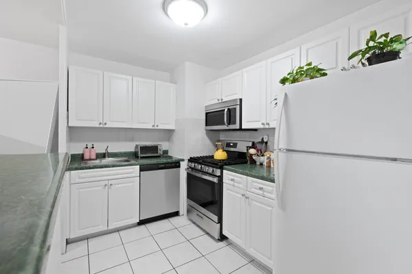 a kitchen with stainless steel appliances granite countertop a refrigerator stove top oven a sink and dishwasher