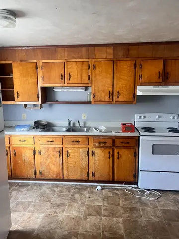 a view of kitchen with stainless steel appliances granite countertop a stove and a sink