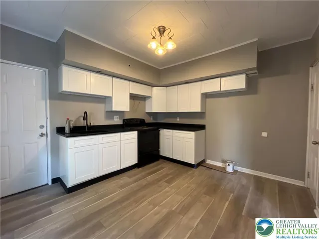 a kitchen with granite countertop white cabinets and white appliances