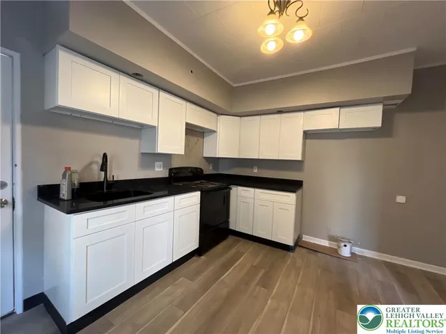 a kitchen with a sink a window and cabinets
