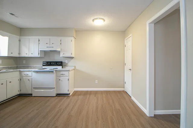 a kitchen with granite countertop white cabinets and white appliances