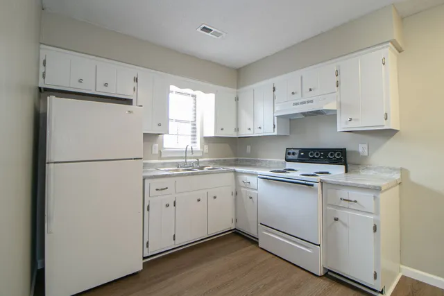 a kitchen with cabinets appliances a sink and a window