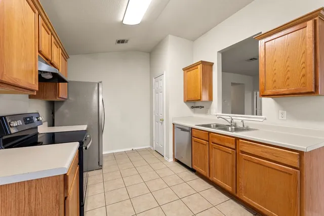 a kitchen with stainless steel appliances a sink stove and cabinets