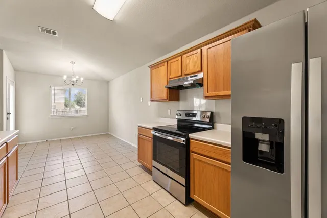 a kitchen with stainless steel appliances granite countertop a stove a sink and a refrigerator