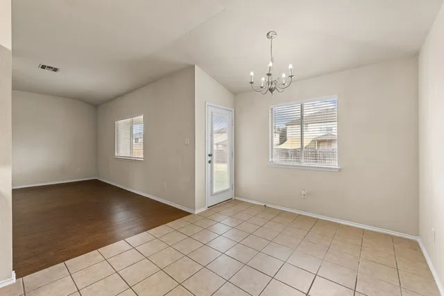 an empty room with windows and chandelier