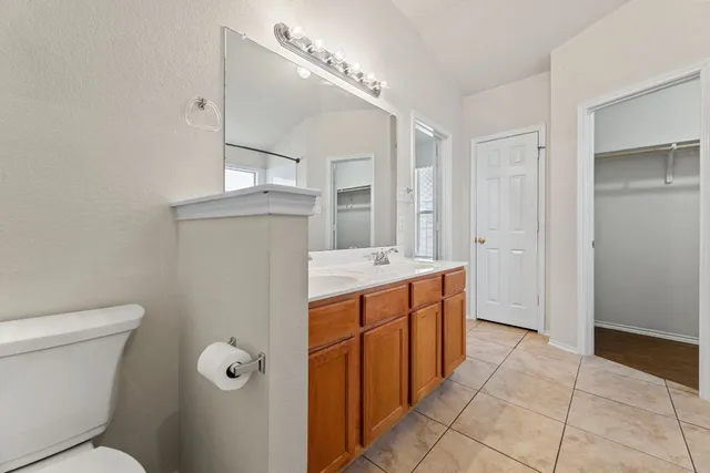 a bathroom with a granite countertop sink mirror vanity and toilet