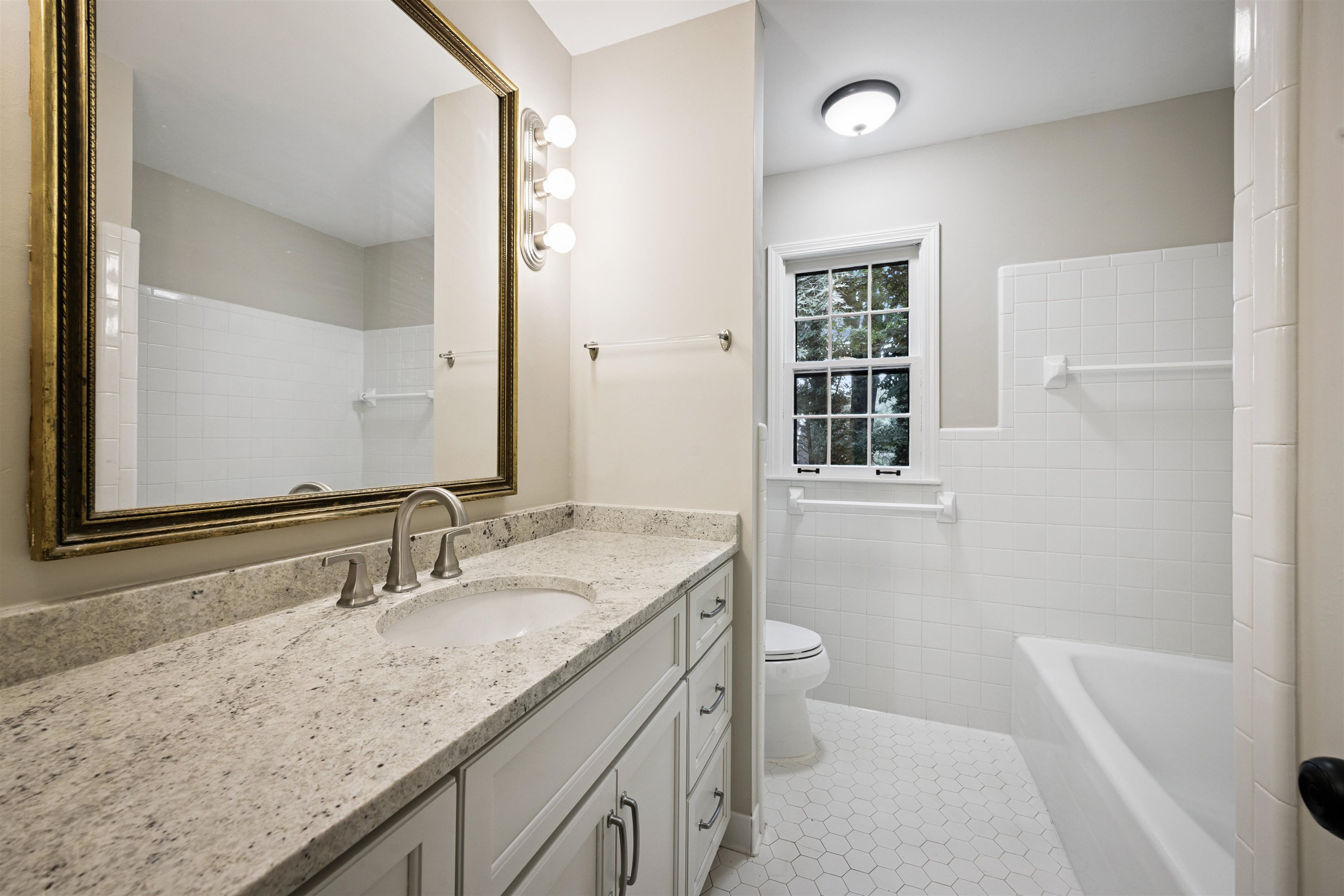 2030 Brierbrook Road Germantown, TN 38138 - Photo 11 of 16 Bathroom featuring vanity, light tile patterned flooring, tile walls, and wainscoting