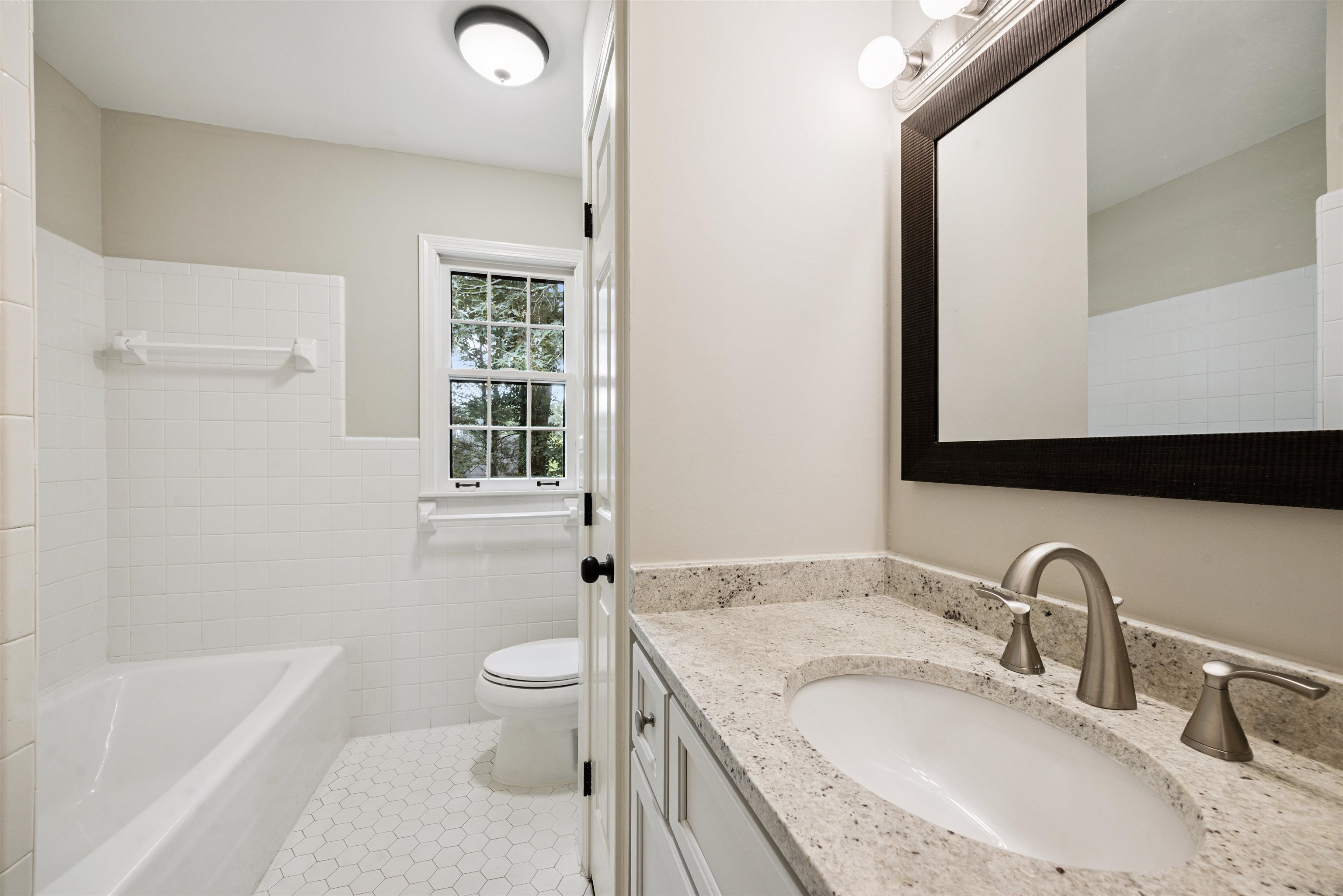2030 Brierbrook Road Germantown, TN 38138 - Photo 14 of 16 Full bathroom featuring vanity, tile walls, wainscoting, light tile patterned floors, and washtub / shower combination