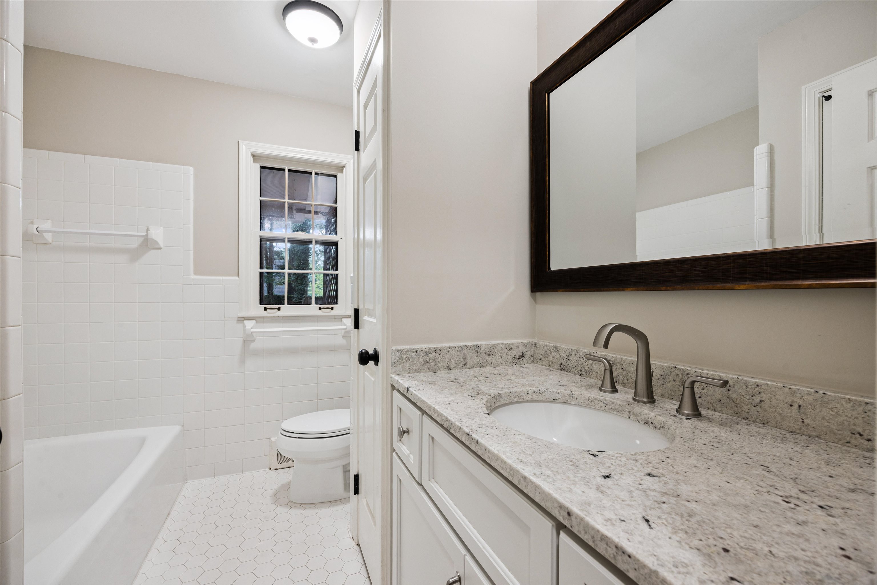 2030 Brierbrook Road Germantown, TN 38138 - Photo 6 of 16 Bathroom featuring vanity, light tile patterned floors, tile walls, and wainscoting