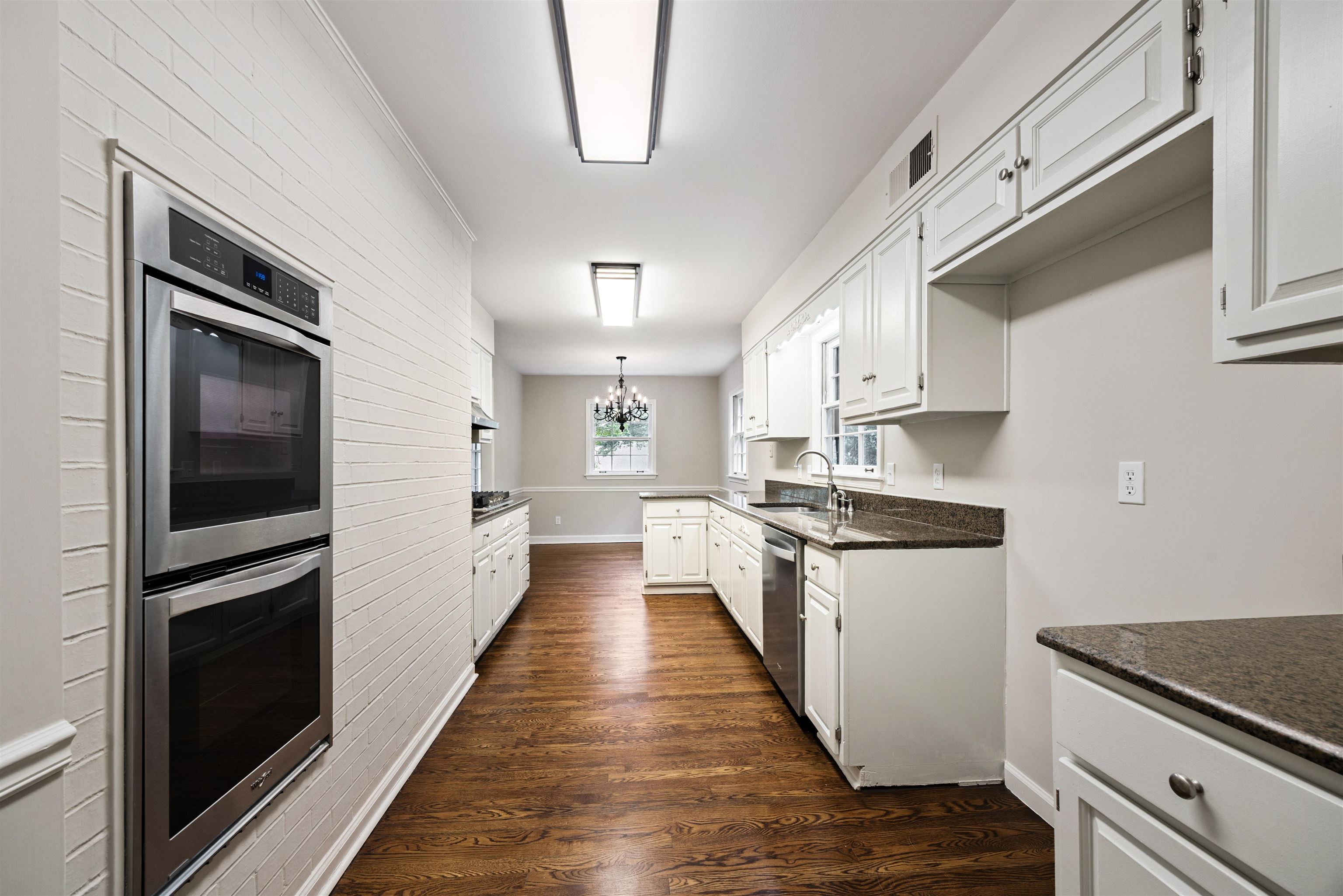 2030 Brierbrook Road Germantown, TN 38138 - Photo 7 of 16 Kitchen featuring a chandelier, stainless steel appliances, dark wood-style floors, white cabinets, and ornamental molding