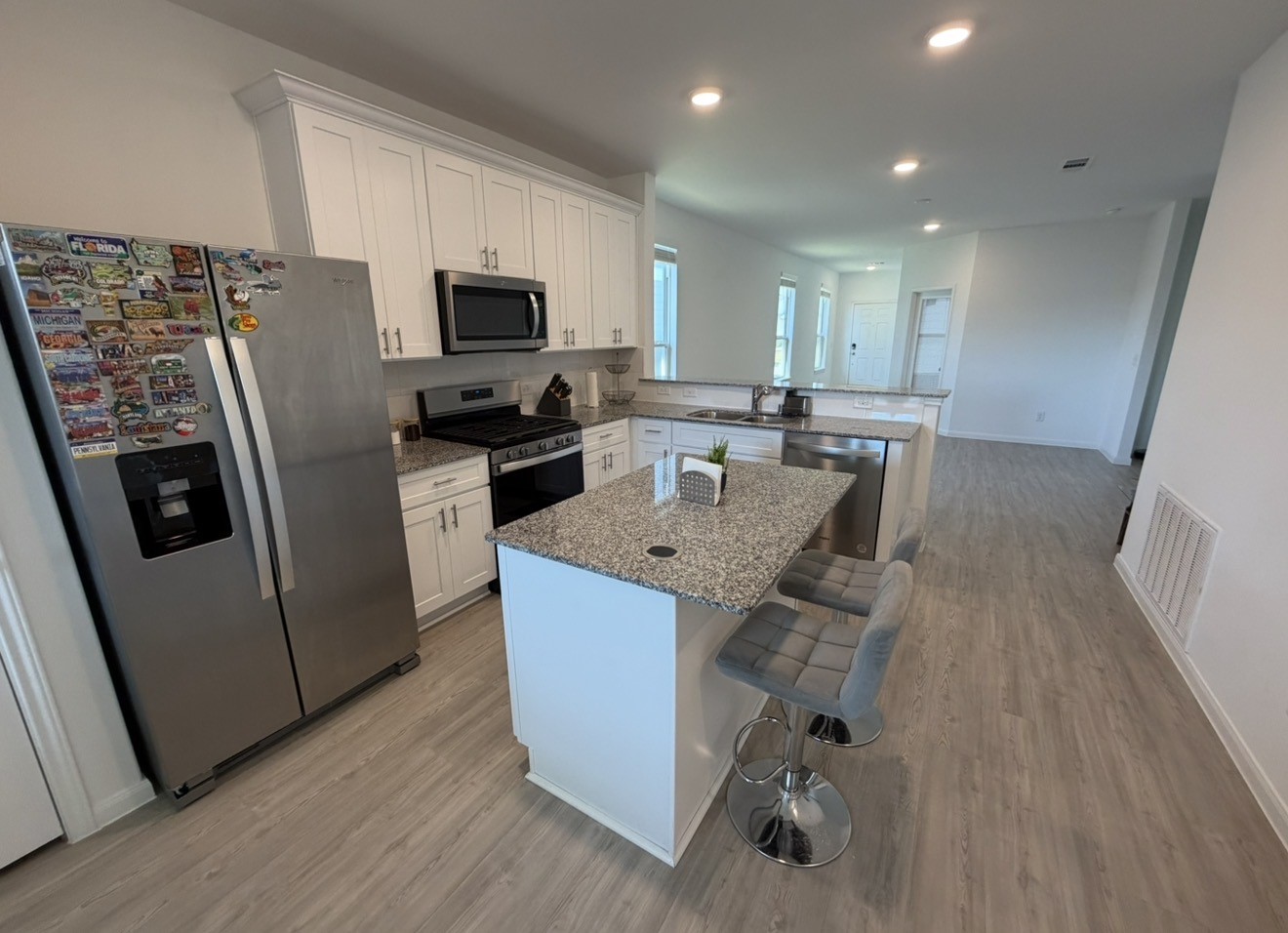 23415 Wagon Cart Road Hockley, TX 77447 - Photo 11 of 26 a kitchen with stainless steel appliances granite countertop a refrigerator oven a sink dishwasher and white cabinets with wooden floor