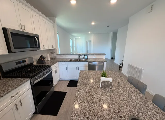 a kitchen with a stove a sink and a microwave