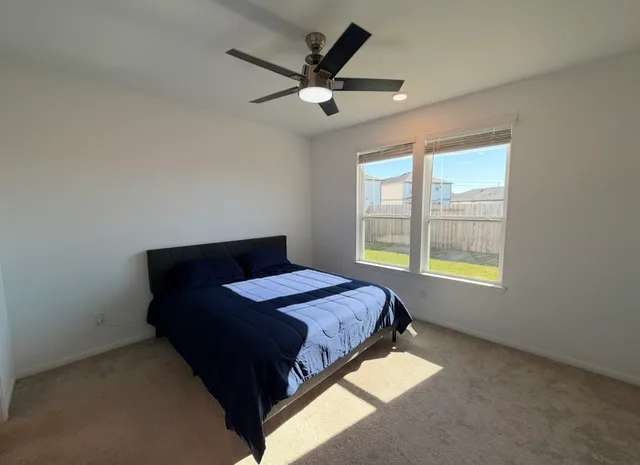 a spacious bedroom with a bed and a flat screen tv