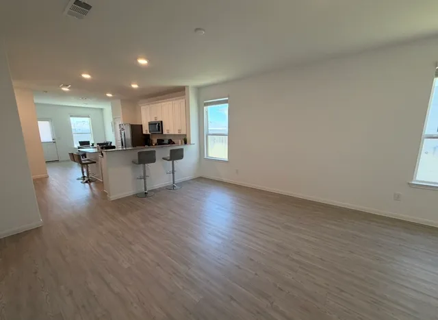 a view of a living room kitchen and a wooden floor