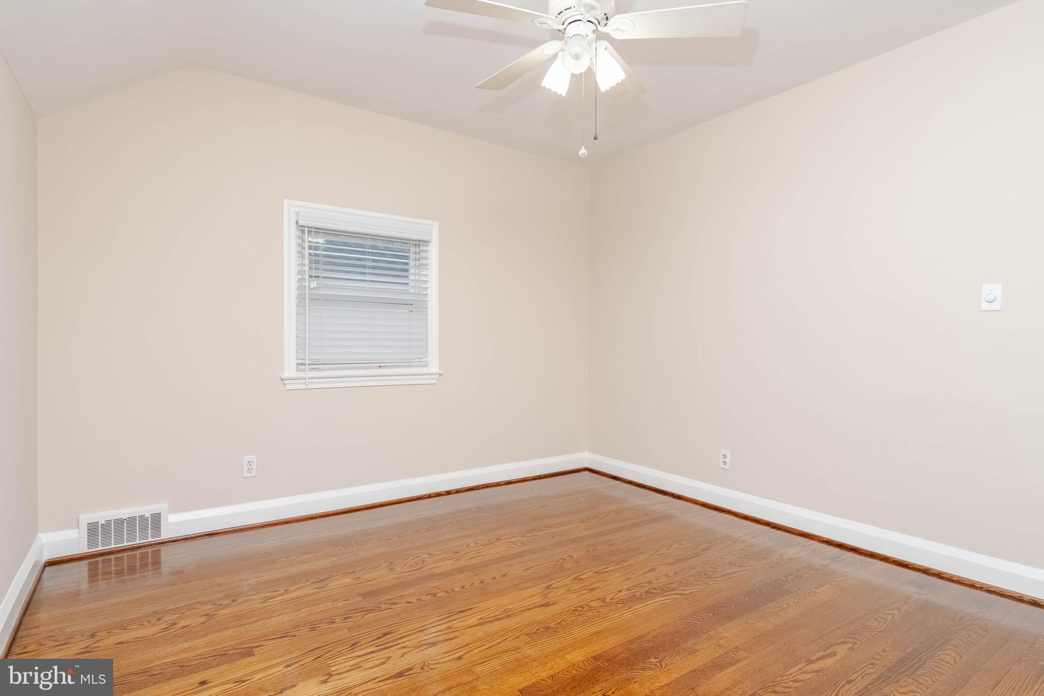 3004 Dunmurry Road Dundalk, MD 21222 - Photo 22 of 40 an empty room with wooden floor fan and windows