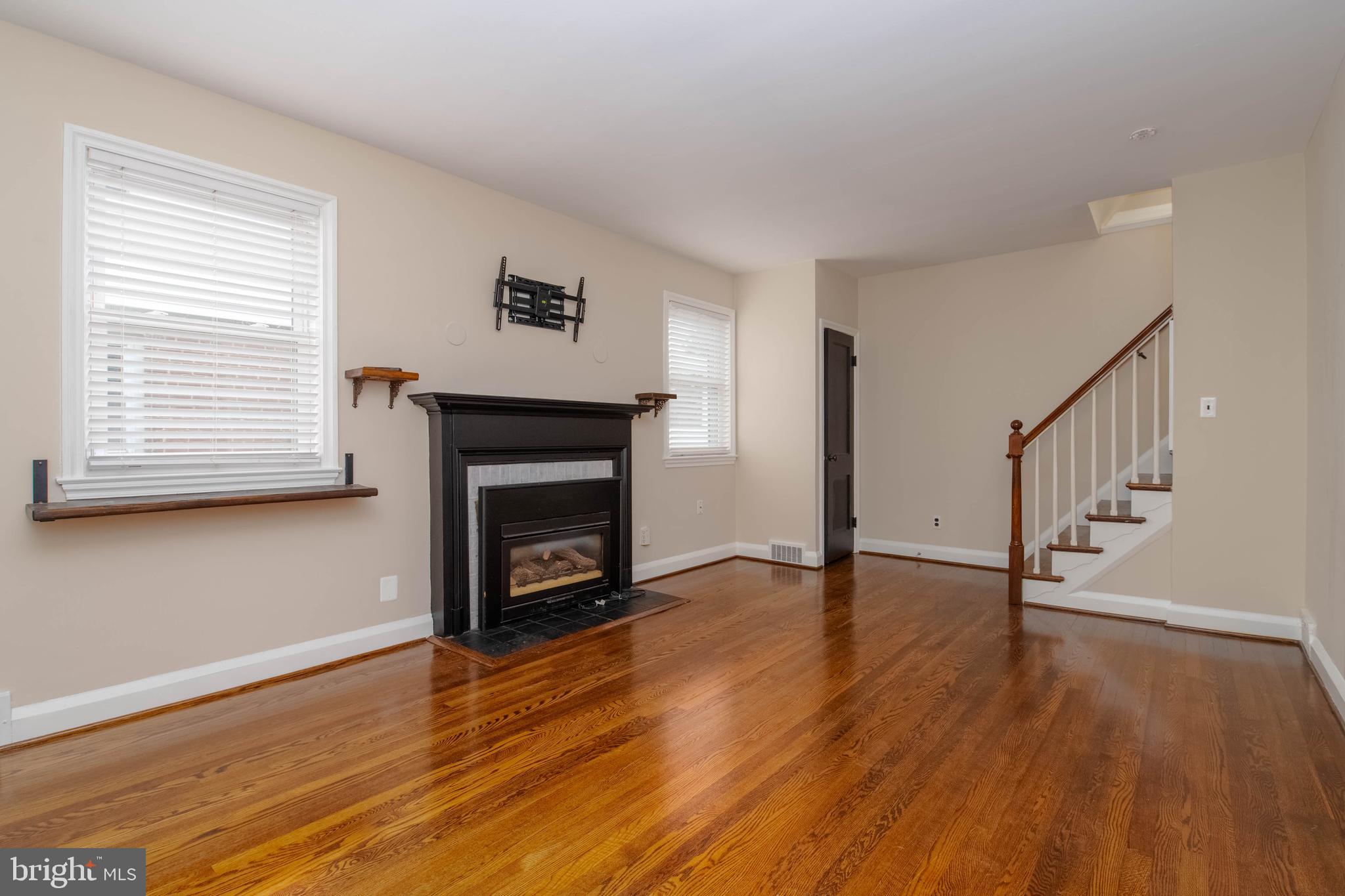 3004 Dunmurry Road Dundalk, MD 21222 - Photo 3 of 40 a view of an empty room with wooden floor fireplace and a window