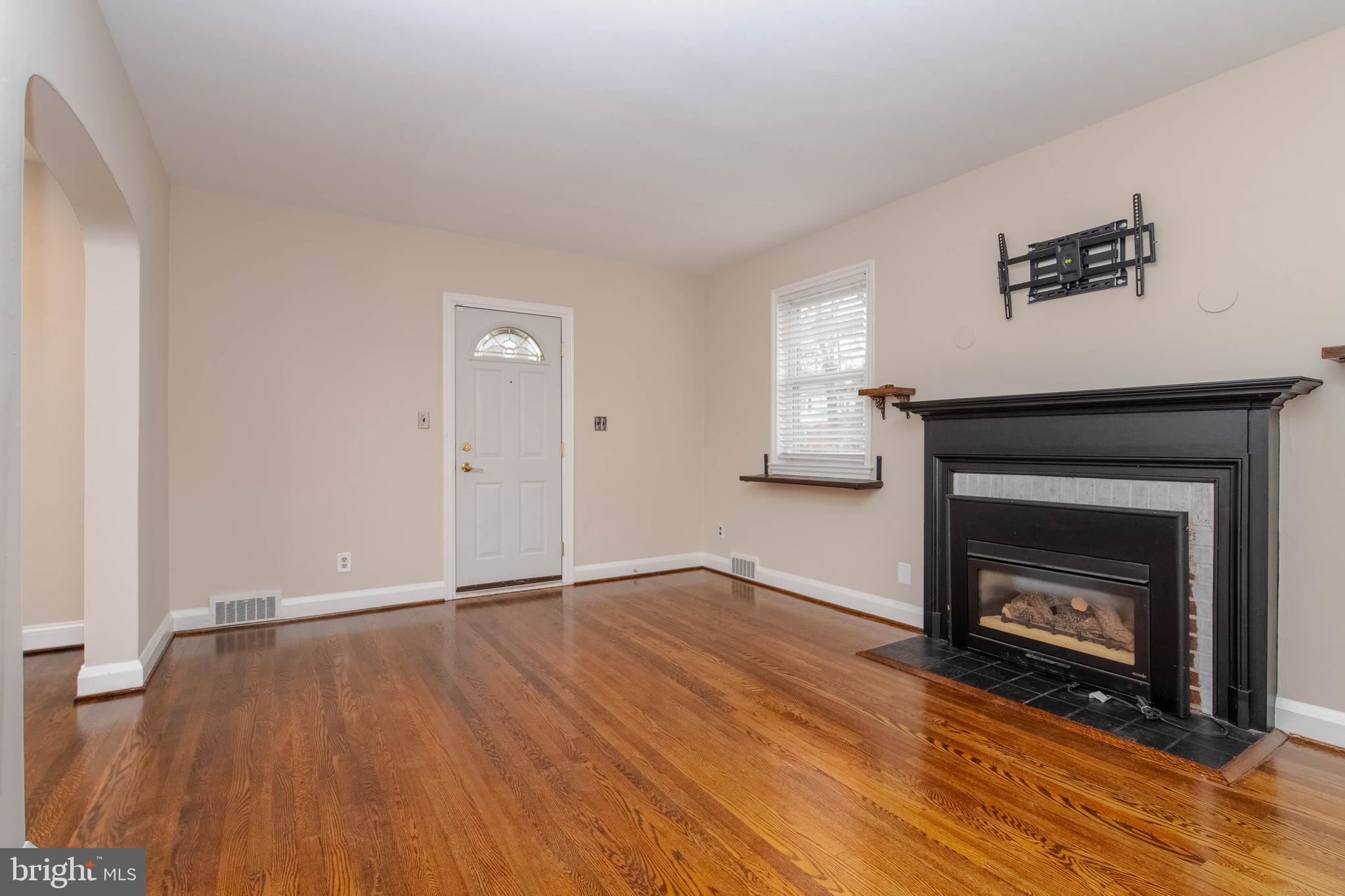 3004 Dunmurry Road Dundalk, MD 21222 - Photo 5 of 40 a view of an empty room with wooden floor and a fireplace
