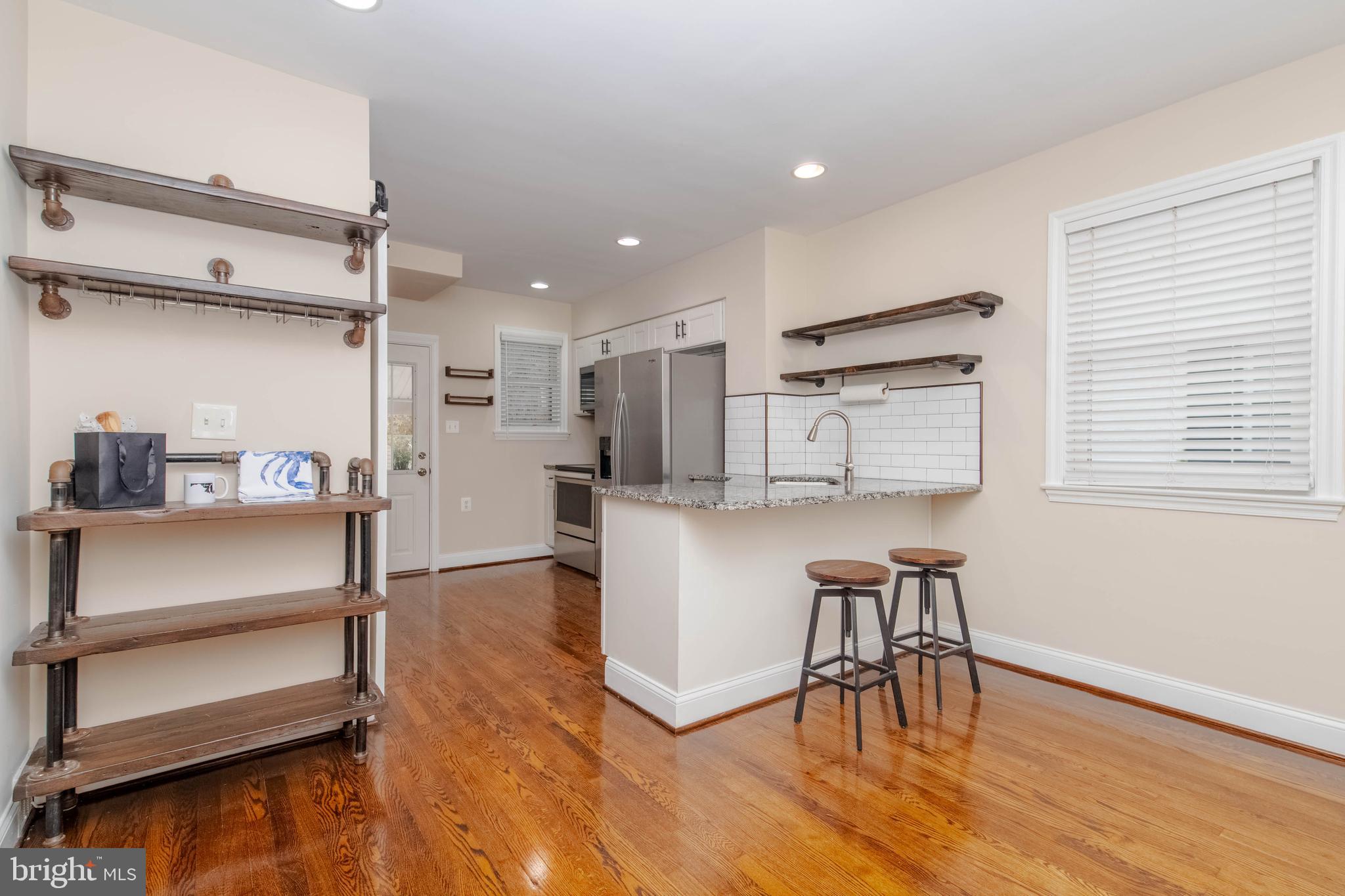3004 Dunmurry Road Dundalk, MD 21222 - Photo 9 of 40 a kitchen with stainless steel appliances refrigerator cabinets dining table and chairs