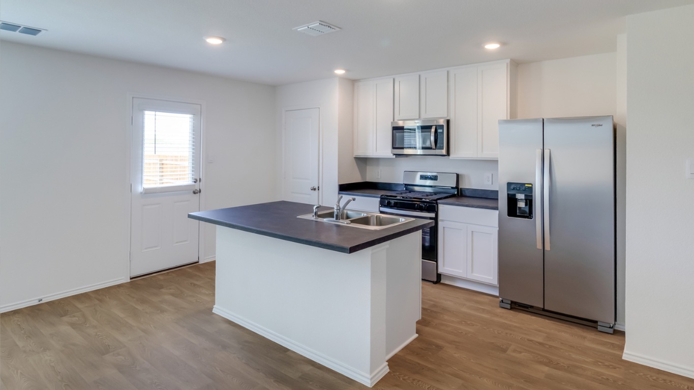 845 Arnold Loop Kyle, TX 78640 - Photo 5 of 17 a kitchen with stainless steel appliances granite countertop a sink stove and refrigerator