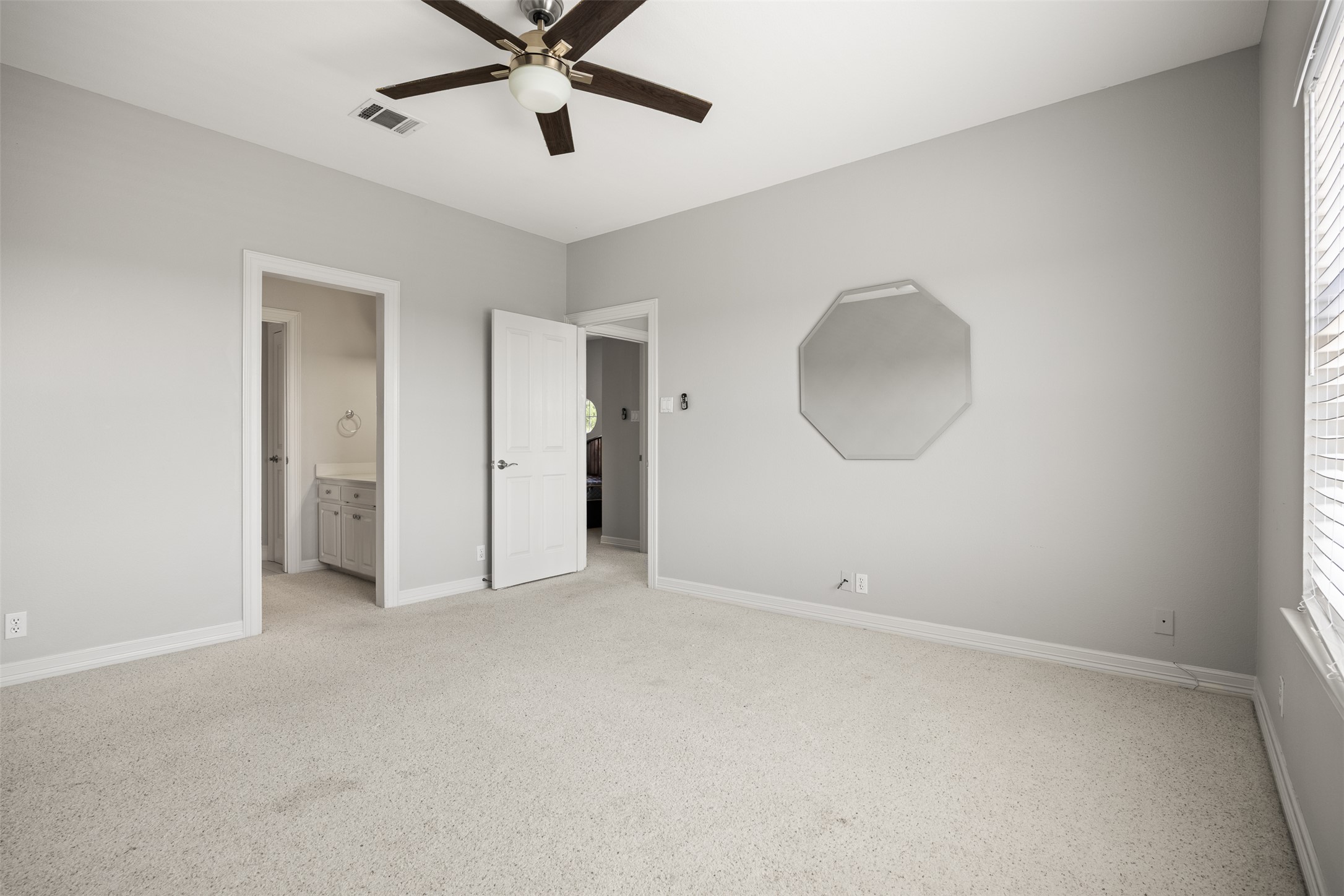 9300 Simmons Road Austin, TX 78759 - Photo 11 of 17 A comfortable bedroom with soft carpet flooring and convenient ceiling fan for ultimate relaxation.