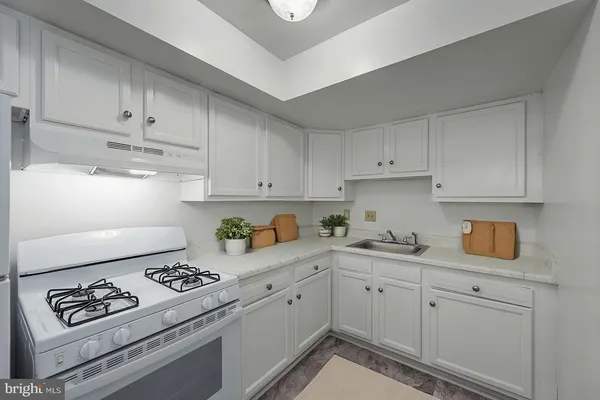 a kitchen with white cabinets and appliances