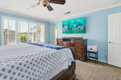 a bedroom with a bed a window and a chandelier