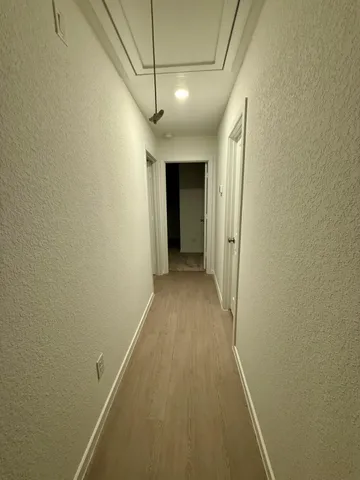 a view of a hallway with wooden floor