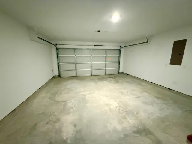 an empty room with projector and windows