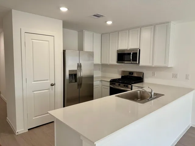 a kitchen with a refrigerator a microwave and cabinets