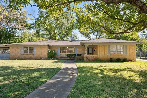 a front view of house with yard and trees