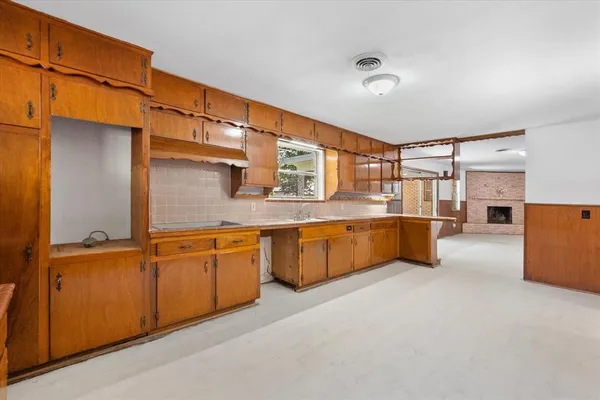 a large kitchen with stainless steel appliances granite countertop a sink and cabinets