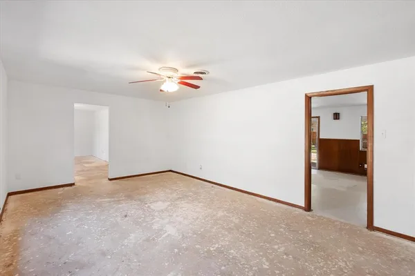 an empty room with closet and fan