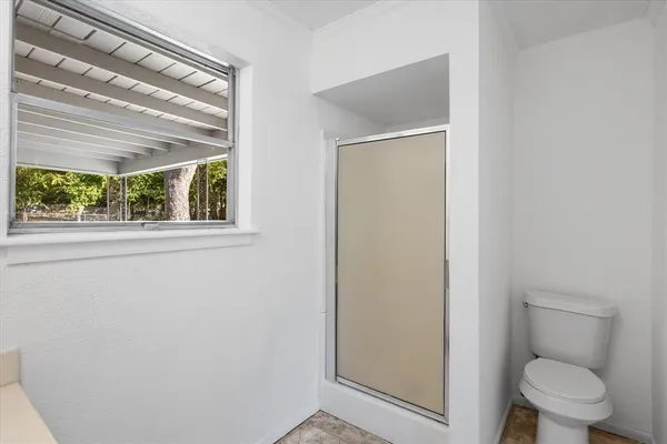 a bathroom with a toilet and a shower