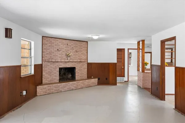 a view of a livingroom with a fireplace and window