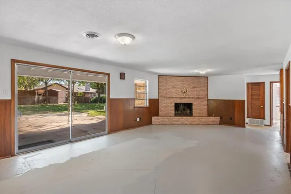a view of an empty room with a fireplace and a window