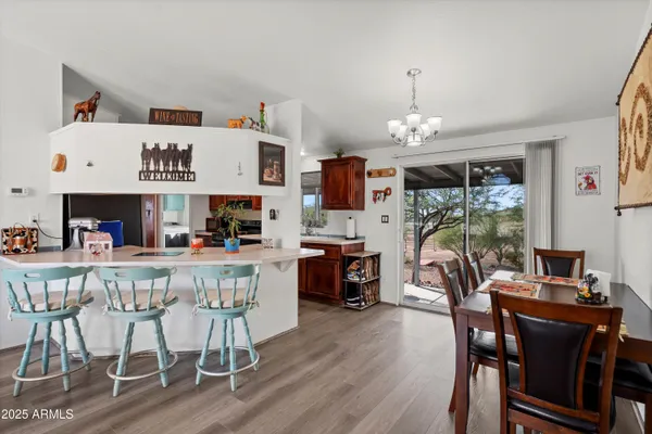 a dining room with wooden floor a chandelier a wooden table and chairs