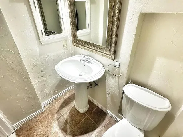 a bathroom with a sink toilet and mirror