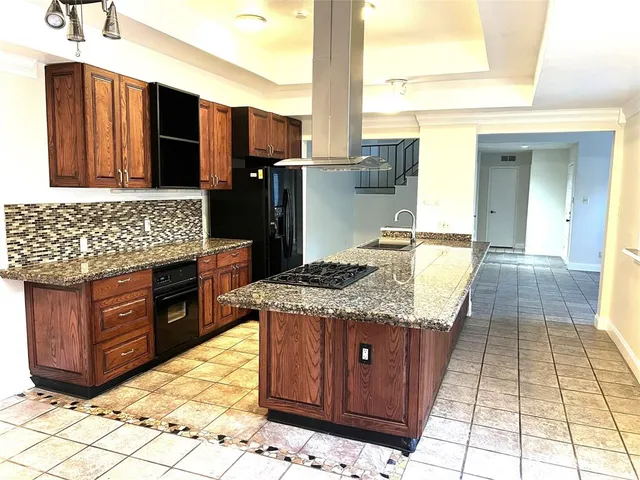 a kitchen with stainless steel appliances granite countertop wooden cabinets and granite counter tops
