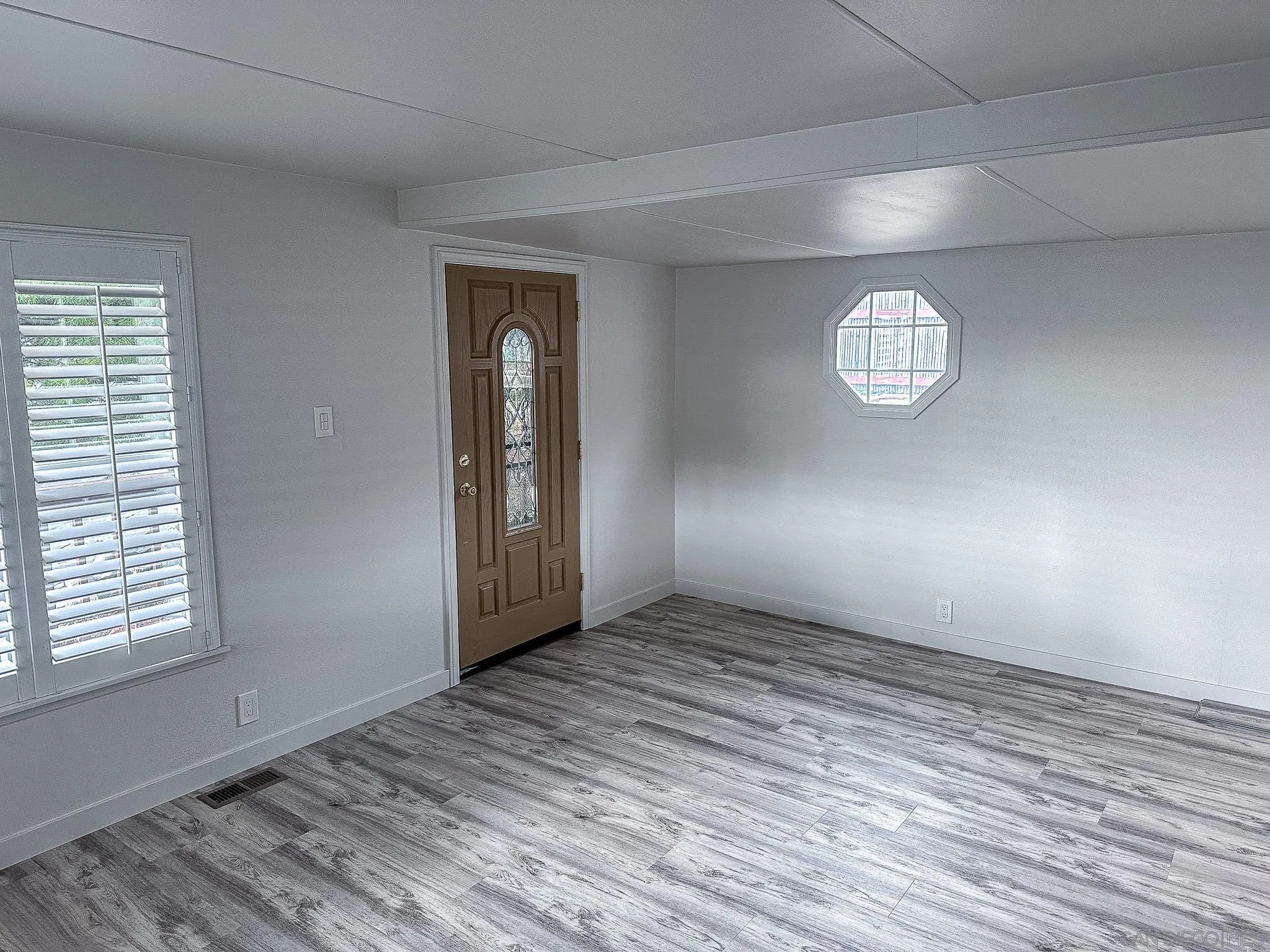 2400 Alpine Boulevard, Unit 17 Alpine, CA 91901 - Photo 3 of 22 an empty room with wooden floor and windows
