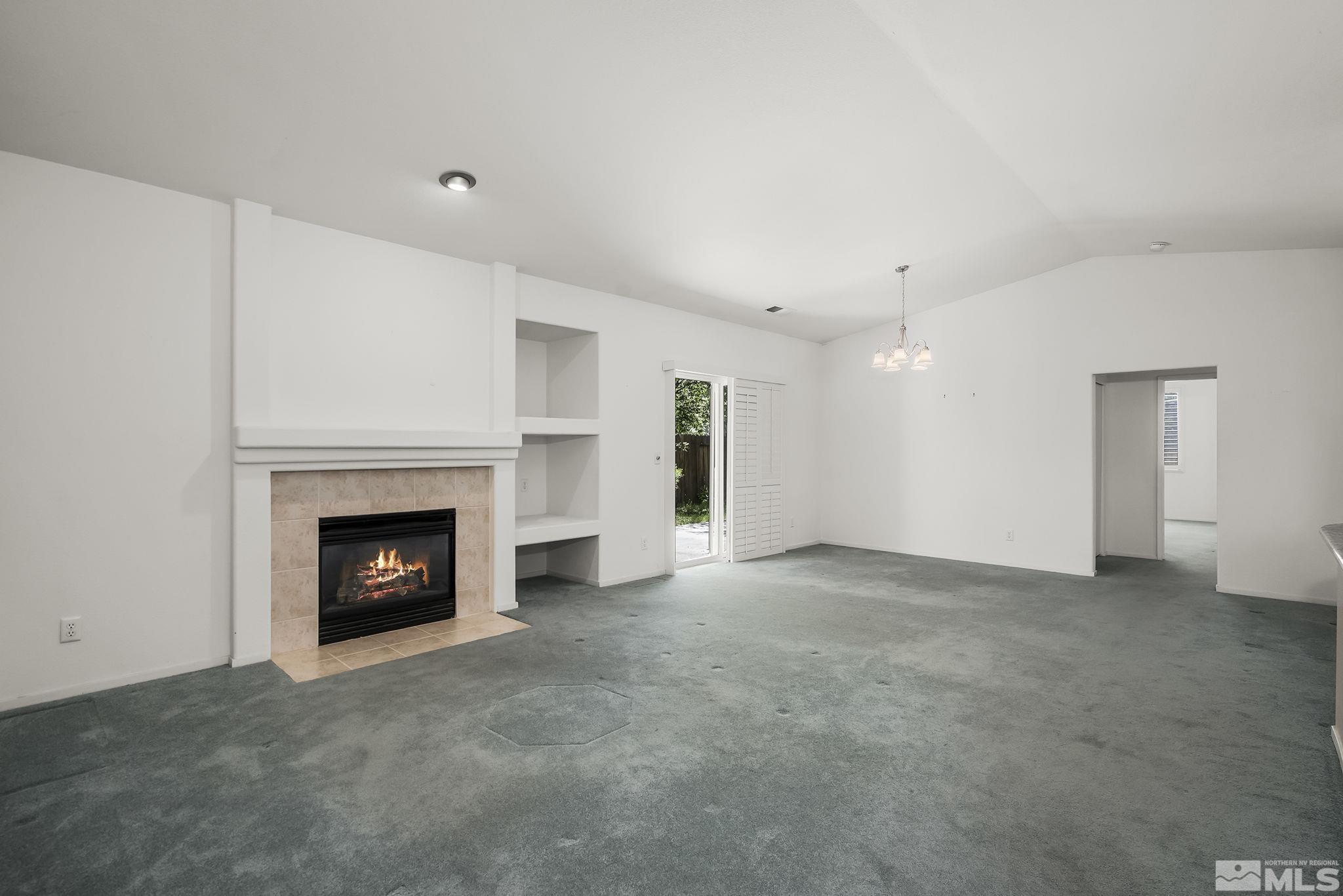 1095 Conifer Drive Minden, NV 89423 - Photo 2 of 19 a view of an empty room with a fireplace and a window