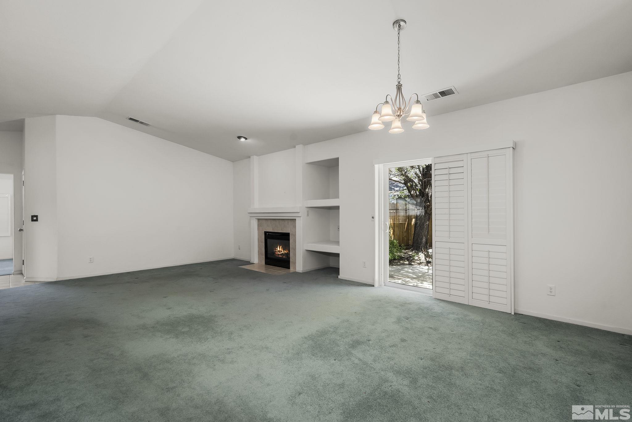 1095 Conifer Drive Minden, NV 89423 - Photo 5 of 19 an empty room with fireplace and windows
