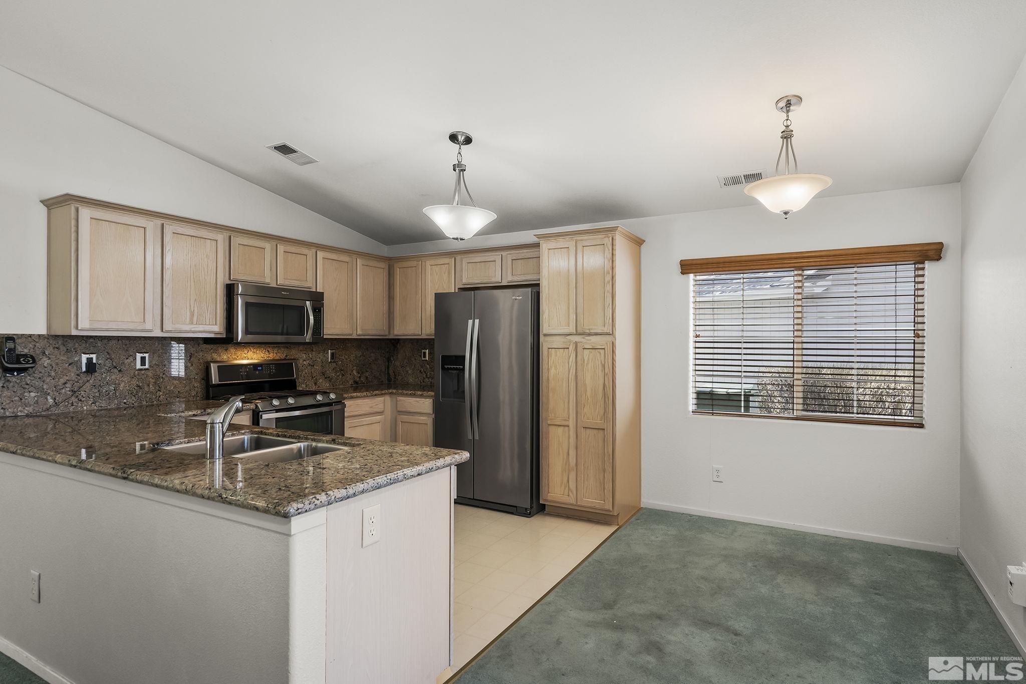 1095 Conifer Drive Minden, NV 89423 - Photo 7 of 19 a kitchen with stainless steel appliances granite countertop a stove refrigerator sink and microwave