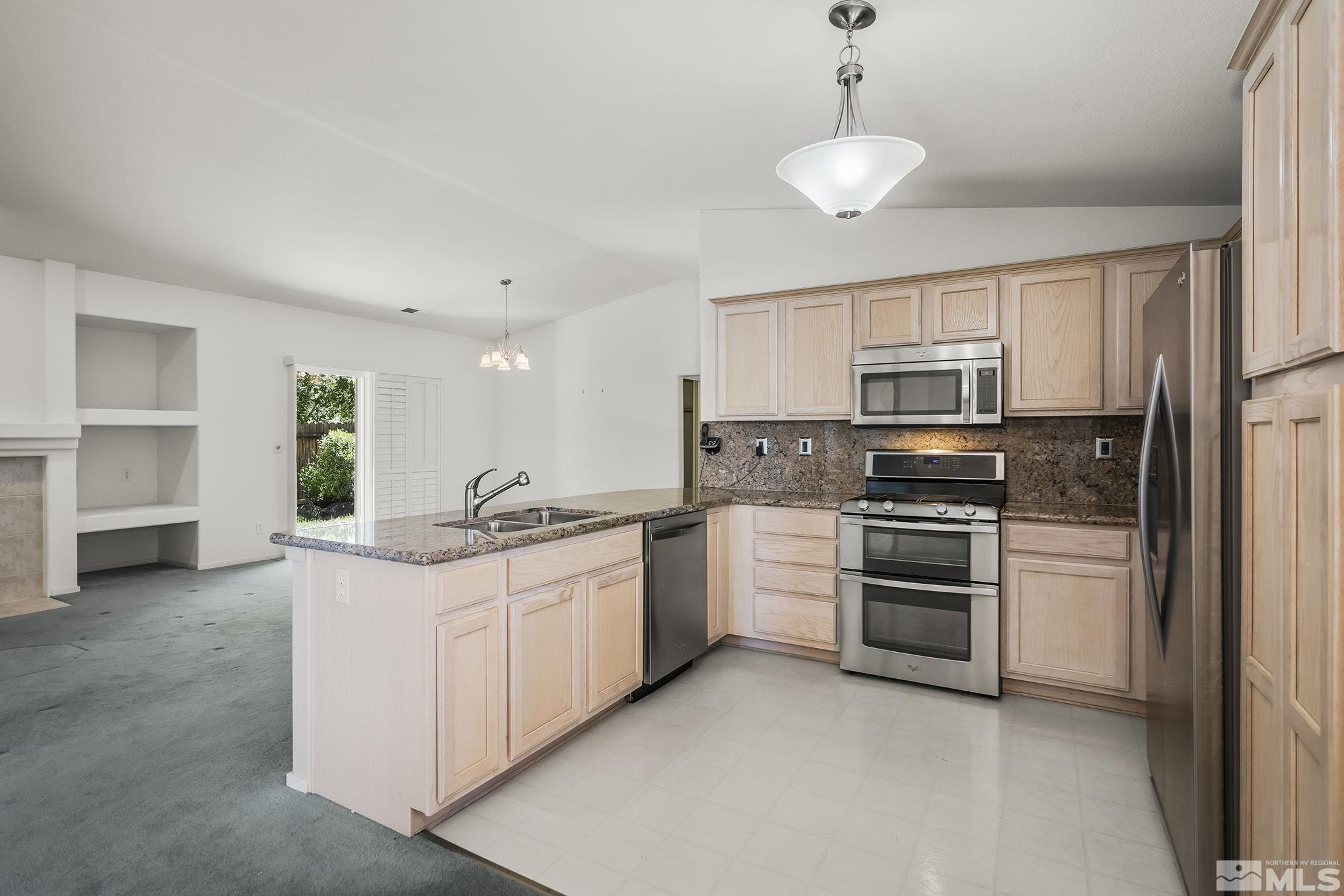 1095 Conifer Drive Minden, NV 89423 - Photo 8 of 19 a kitchen with stainless steel appliances granite countertop a sink and a refrigerator