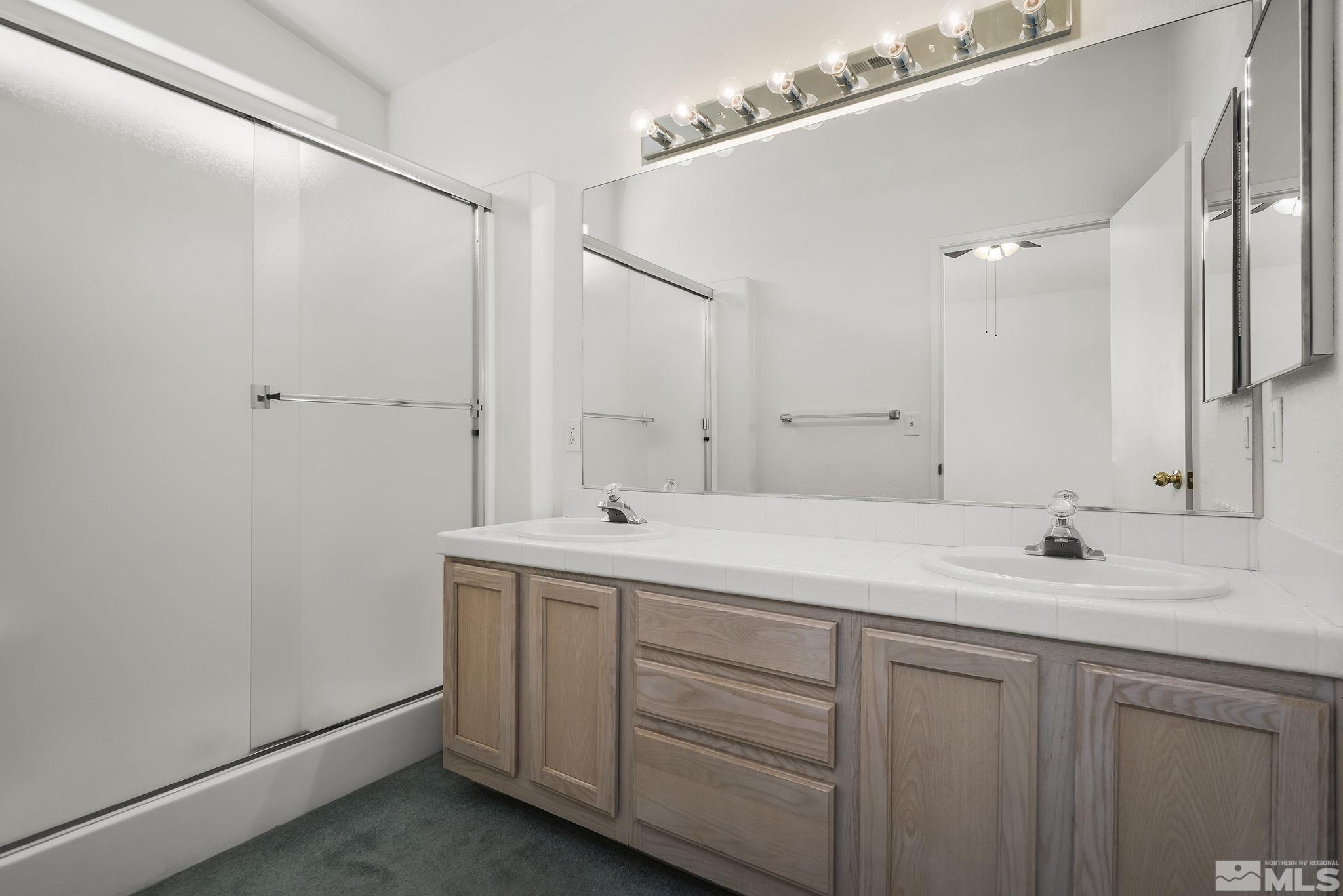 1095 Conifer Drive Minden, NV 89423 - Photo 10 of 19 a bathroom with a double vanity sink and mirror