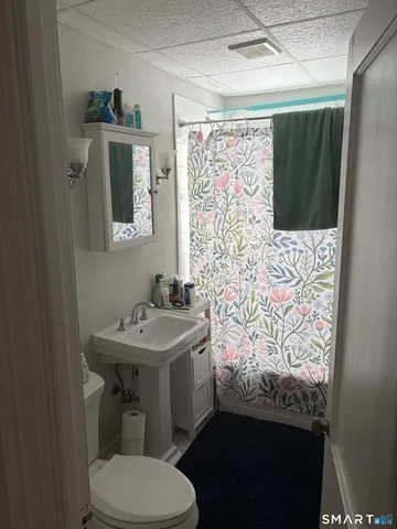 a bathroom with a toilet sink and mirror