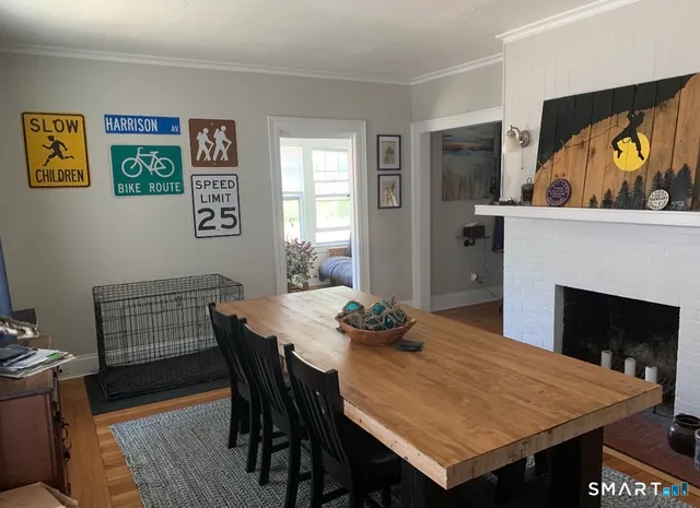 a view of a dining room with furniture wooden floor and a fireplace